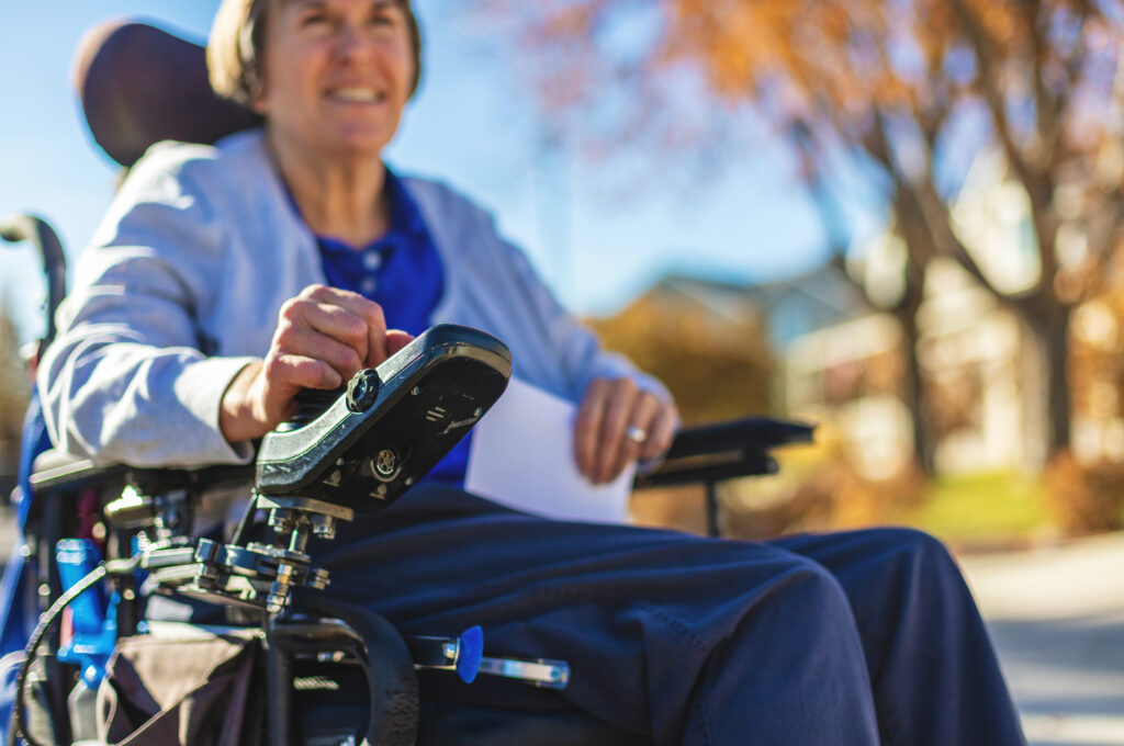 Frau mittleren Alters mit multipler Sklerose im elektrischen Rollstuh