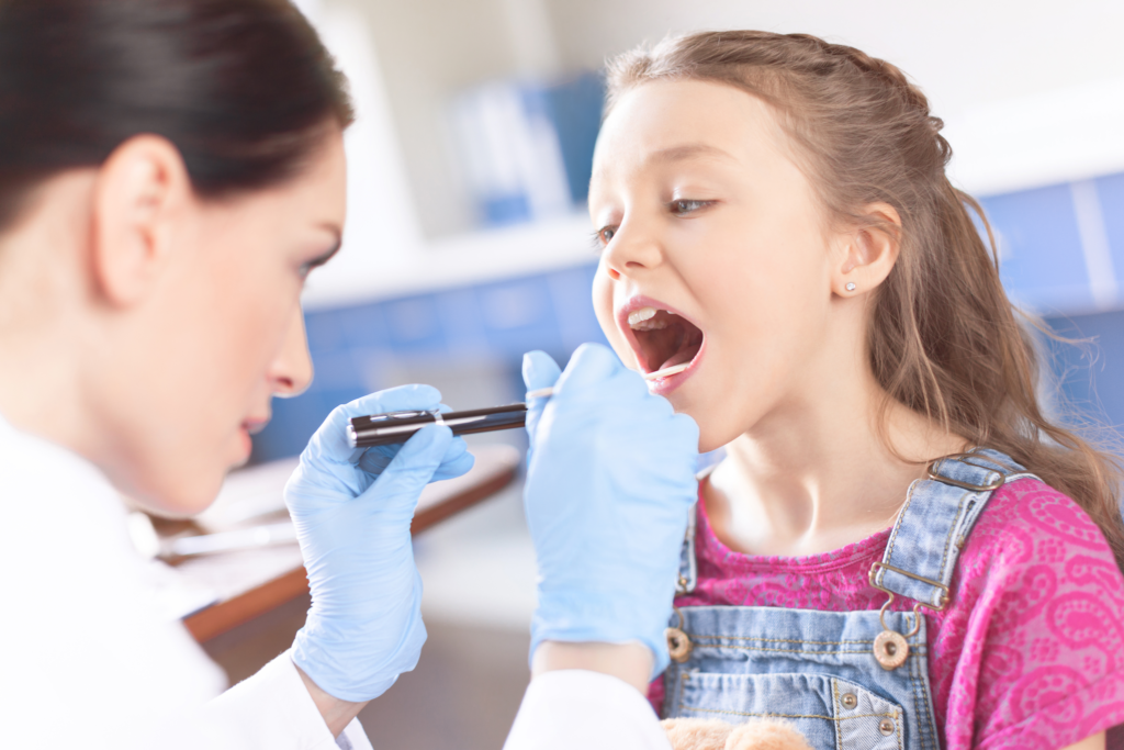 Ärztin untersucht Kind auf Halsschmerzen